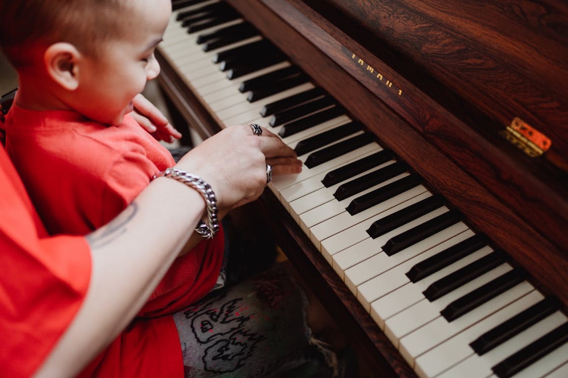 A child playing a piano Description automatically generated with medium confidence
